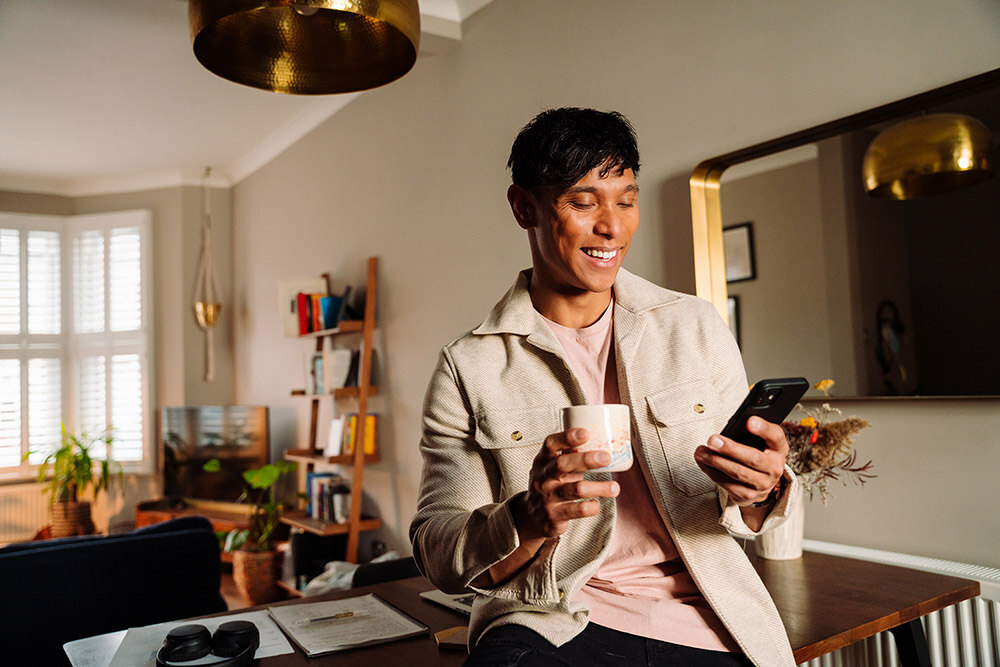 Man browsing on his phone with a coffee in hand, reflecting customer expectations for responsive and great customer service